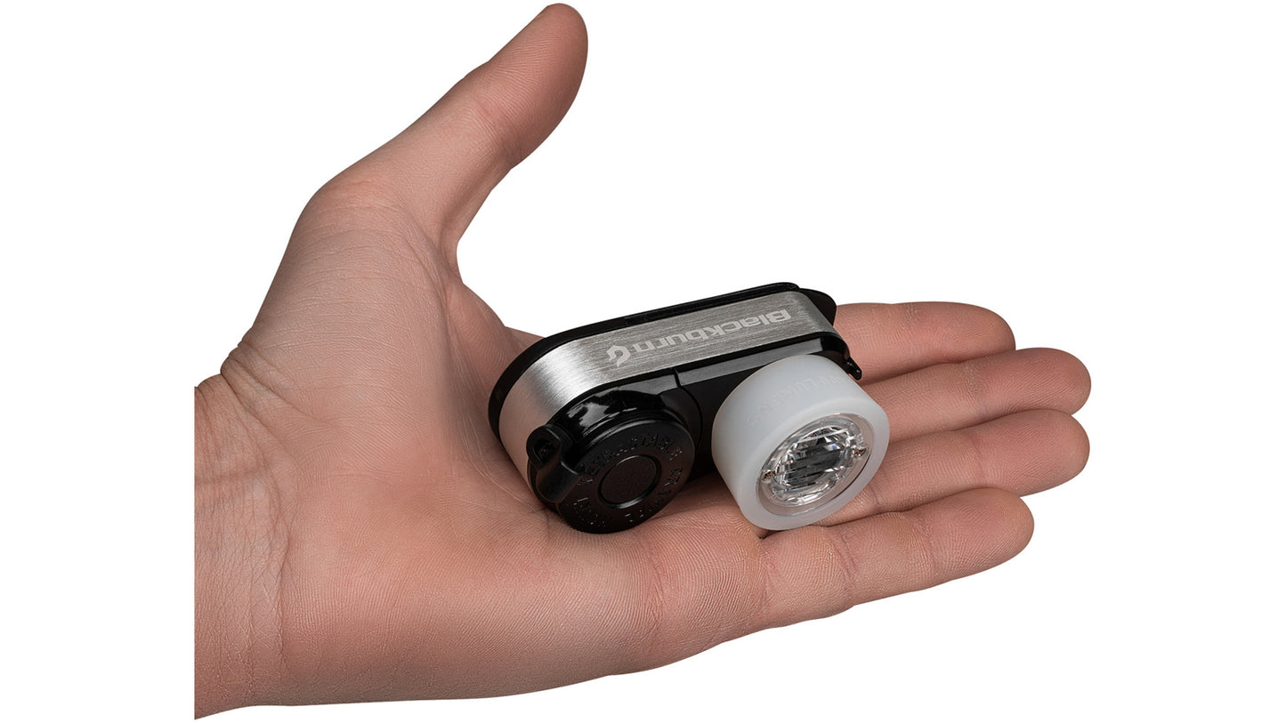 De compacte Blackburn Outpost lamp wordt in een hand gehouden om de kleine afmetingen te tonen.