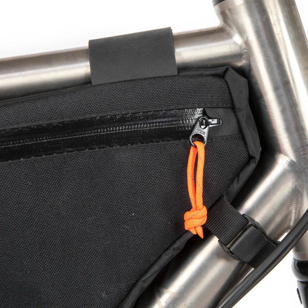Close-up van de YKK Aquaguard rits met oranje paracord-lipje op de Restrap Frame Bag.