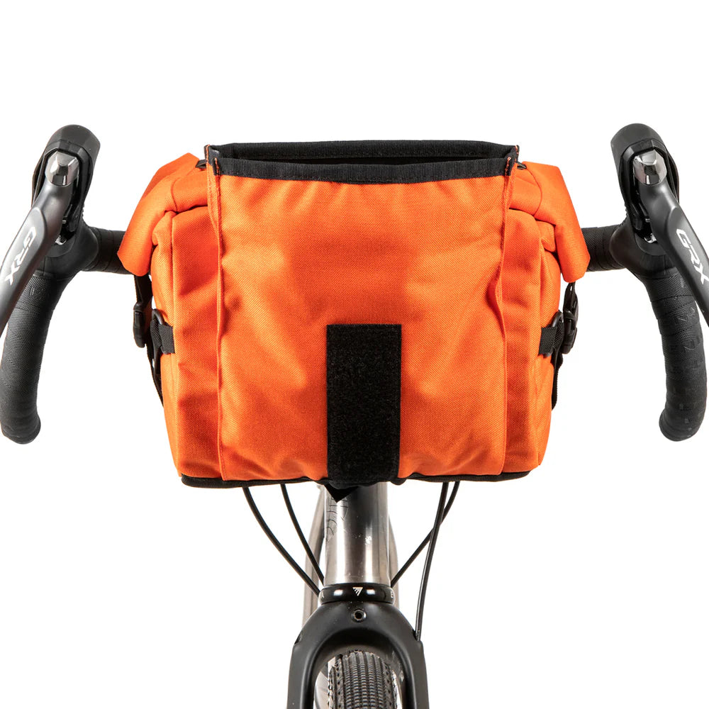 Geopende oranje Restrap Bar Pack 10L stuurtas, vooraanzicht op een fietsstuur.