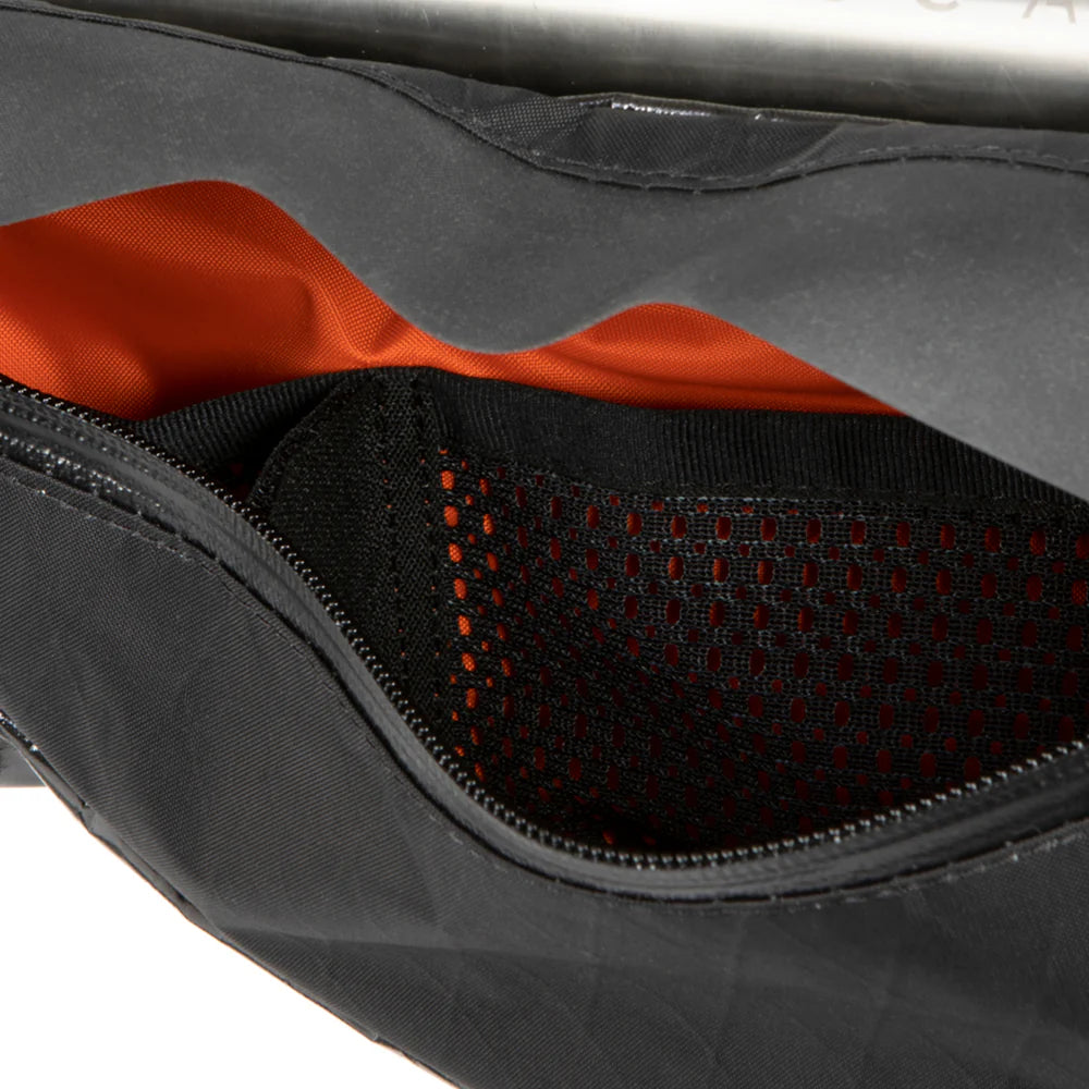 Close-up van de binnenkant van de Restrap Race Frame Bag met de oranje voering en het mesh opbergvak.