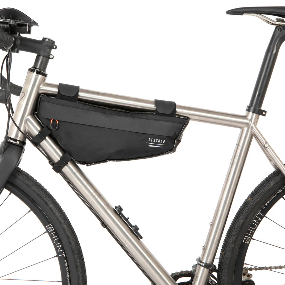 Linker zijaanzicht van zwarte Restrap Race Frame Bag small gemonteerd in de driehoek van een titanium gravelbike frame.