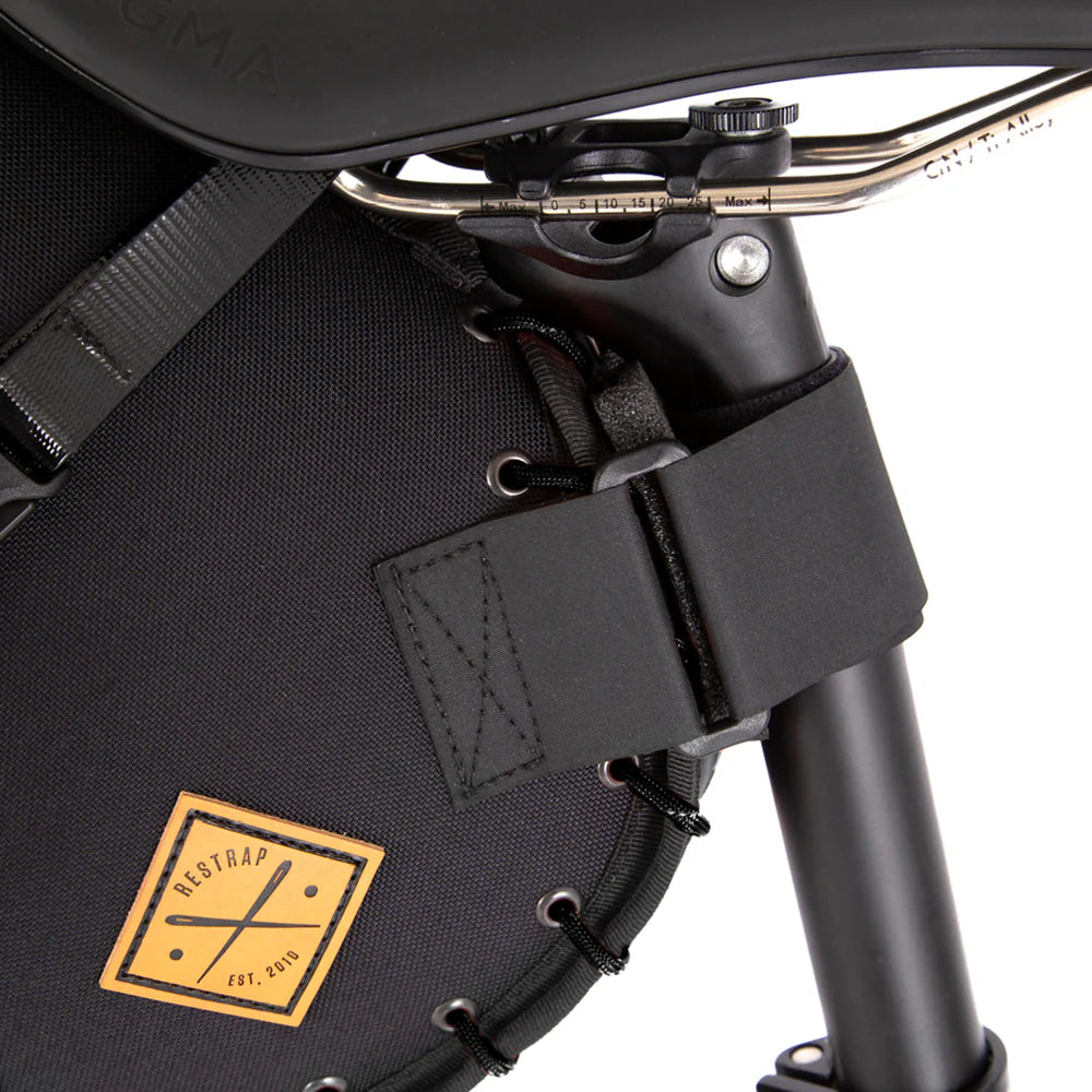 Close-up van de zadelpen-bevestiging en het PU-lederen Restrap label op de zadeltas holster.