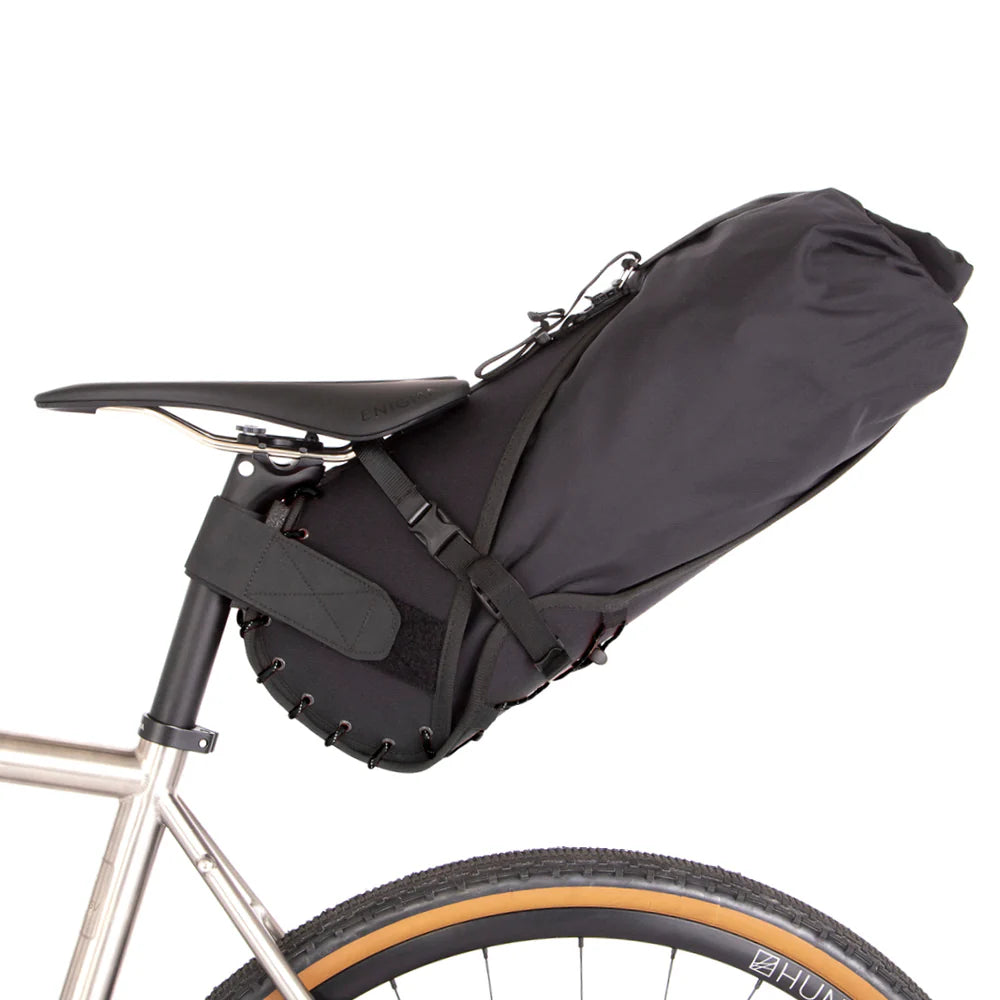 Zijaanzicht van de Restrap Saddle Bag 14L, volgepakt en klaar voor een bikepacking tocht.