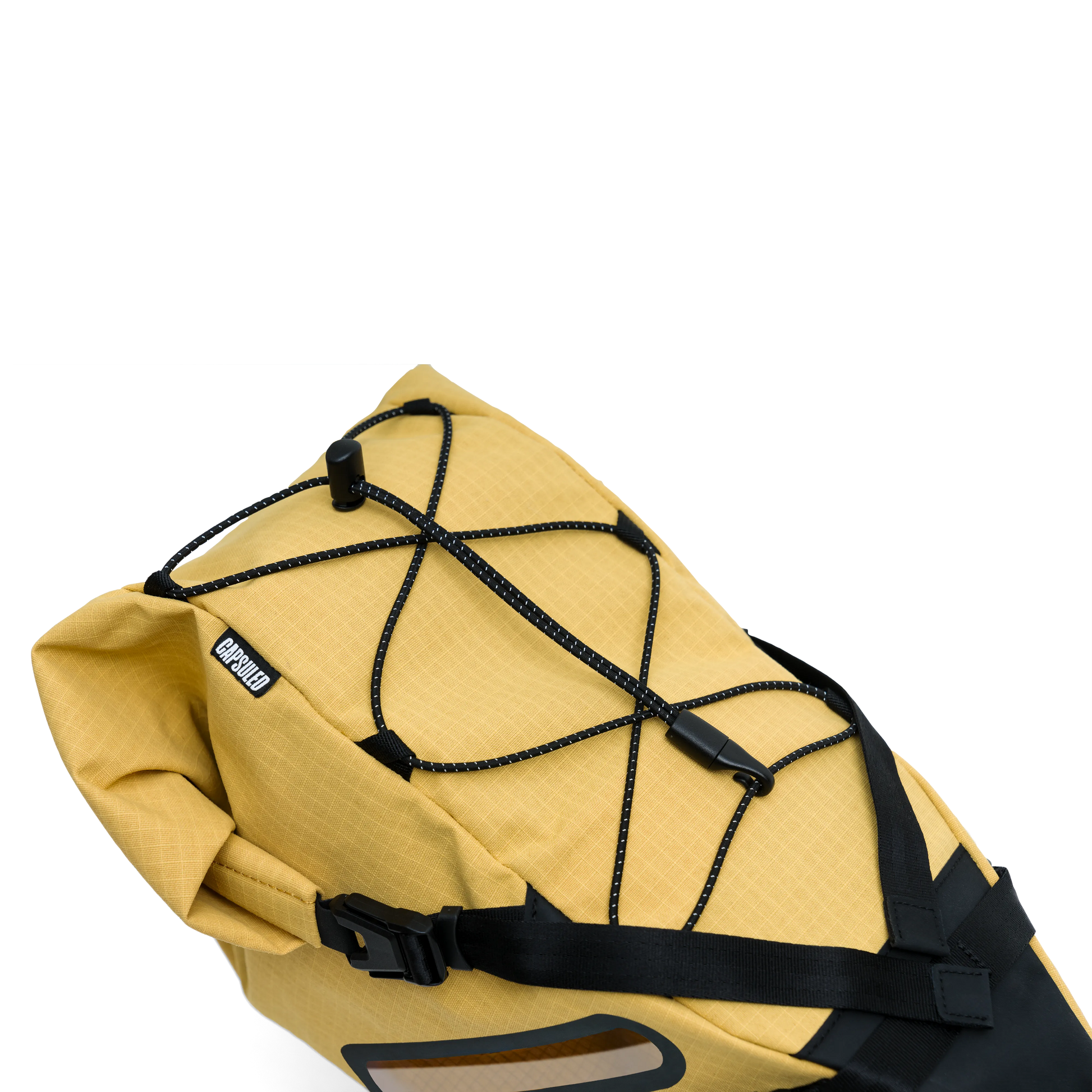Bovenaanzicht van de gele Capsuled Saddle Bag met het externe bungee koord en het merklabel.