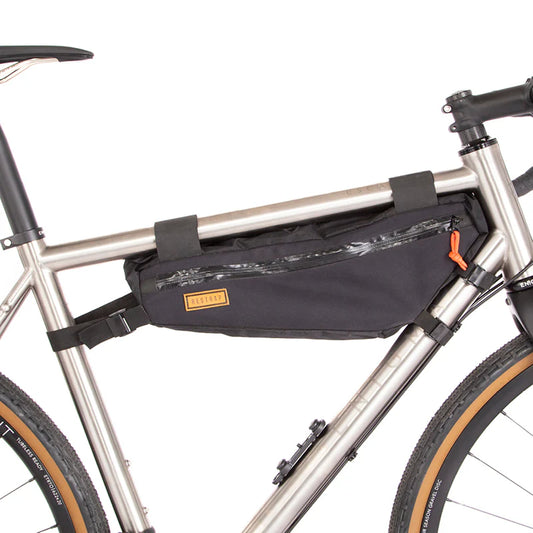 Zijaanzicht van de Restrap Frame Bag Medium, gemonteerd in het frame van een titanium gravelbike.