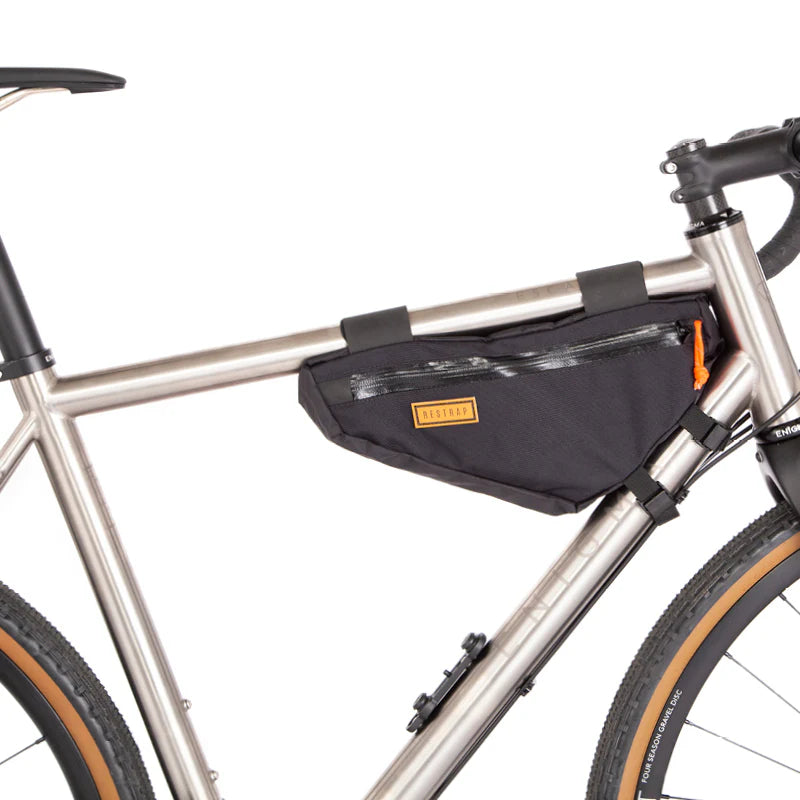 De compacte Restrap Frame Bag Small gemonteerd in de voorste driehoek van een titanium gravelbike.