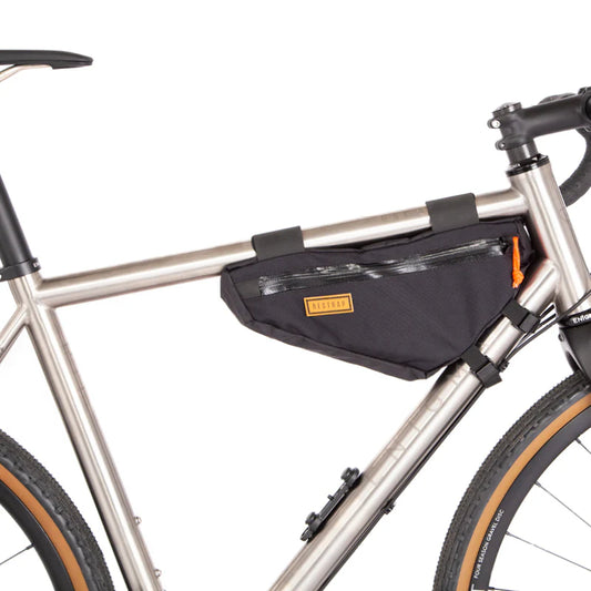 De compacte Restrap Frame Bag Small gemonteerd in de voorste driehoek van een titanium gravelbike.