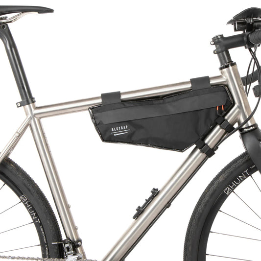 De zwarte Restrap Race Frame Bag small gemonteerd in de driehoek van een titanium gravelbike frame.