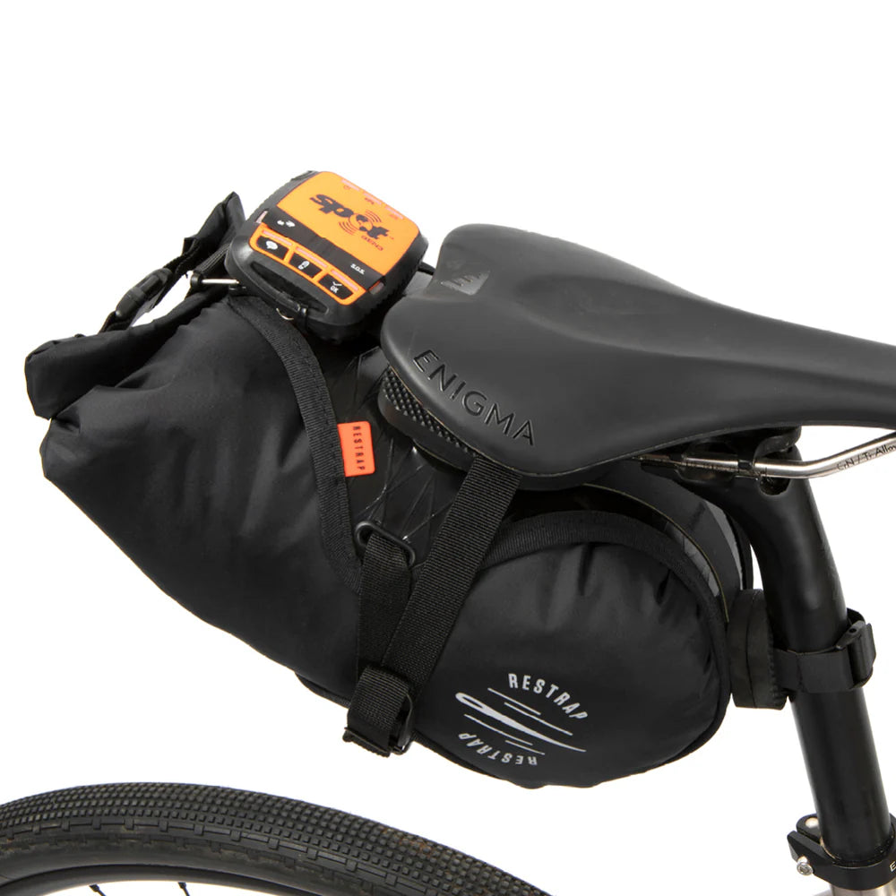 Restrap Race Saddle Bag met een SPOT tracker bevestigd, wat de veelzijdigheid toont.